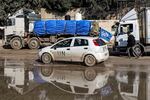 A U.N. vehicle moves past trucks carrying humanitarian aid entering the Gaza Strip through the Kerem Shalom border crossing in the southern part of the Palestinian territory on Monday, Jan. 29.