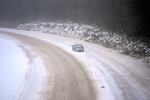 A car slowly navigates a snow-covered interstate Sunday, Jan. 5, 2025, in St. Louis.  