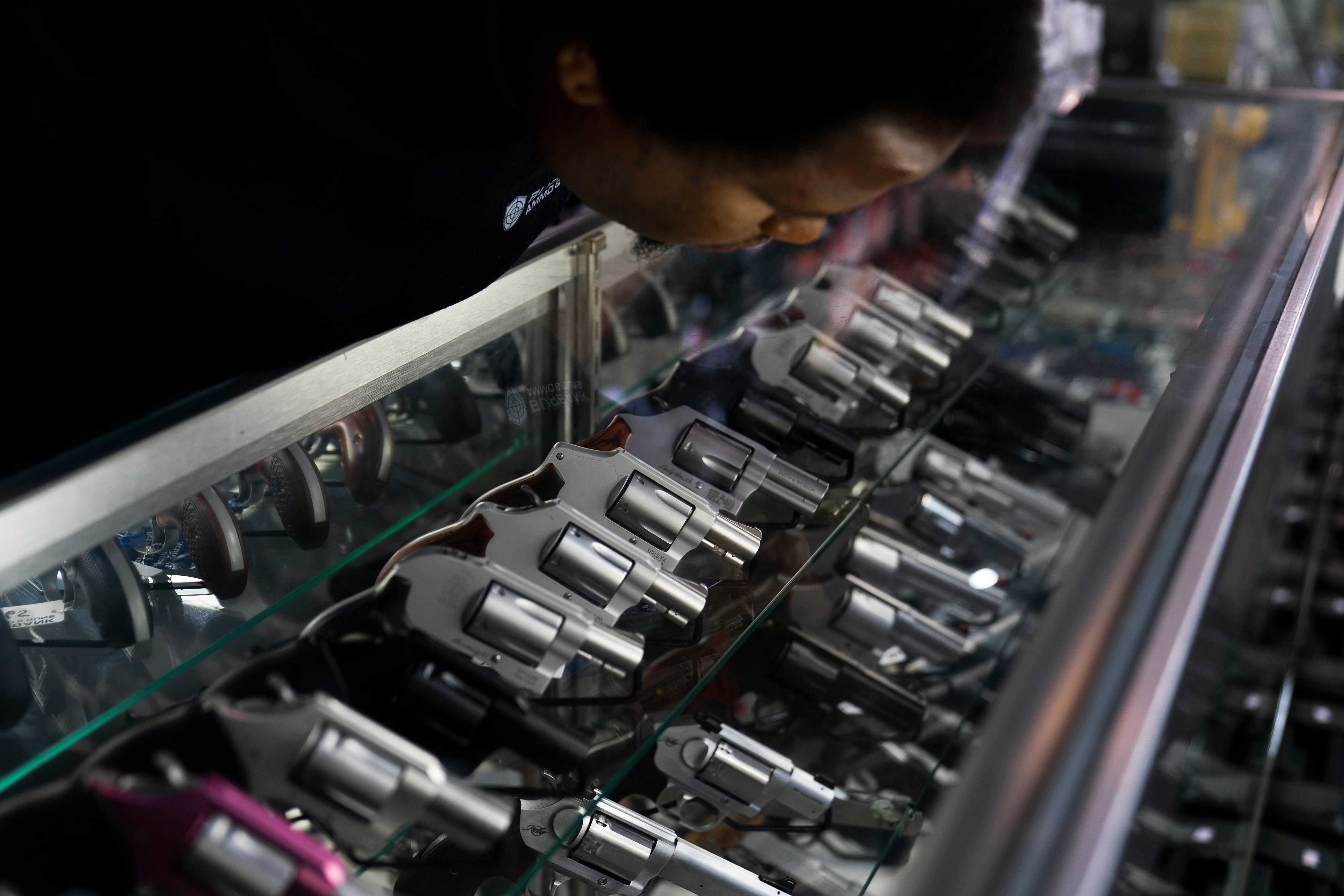 FILE - A sales associate arranges a display of guns at a firearms store in Burbank, Calif., Thursday, June 23, 2022.