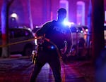 A police officer hangs yellow crime tape at Brown University in Providence, R.I., on Dec. 13, 2025, during the investigation of a shooting.