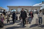 Iranians carrying their belongings arrive in Turkey after passing through a border crossing.