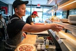 Aaron Truong, co-owner of Hapa Pizza in Beaverton, Ore., receives a customer’s order, Aug. 9, 2024. Hapa experienced a 200% increase in sales from June to July 2024 after being featured in an article by The New York Times.