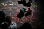 Children draw with chalk during a candlelight vigil at Drake Park after three children and a teacher were killed in a shooting at Silver Rail Elementary School in Bend, Ore. on Oct. 15, 2026.
