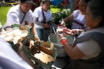 Los voluntarios en la Guelaguetza preparan tejate, un brebaje oaxaqueño tradicional, para entregárselo a los asistentes y artistas.