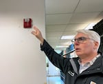 Cary Morris, assistant director of Operations and Maintenance at Portland State University, points out damage done to a fire alarm, May 6, 2024, after protesters occupied the library for several days last week. 