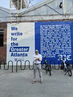 Andrew Morse, the publisher and chief executive of The Atlanta Journal-Constitution, stands before a mural spelling out the newspaper's mission. 