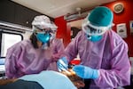 Pacific University dental hygiene student Maria Guerrero, left, watches as expanded practice dental hygienist Wilber Ramirez-Rodriguez examines Omar Solano's teeth aboard the SmileCare Everywhere Mobile Dental Clinic in Beaverton, April 1, 2021.