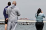 People in Orchard Beach looking at the Dali container ship and collapsed Francis Scott Key bridge.