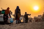A Rohingya refugee woman walks home, carrying a container of drinking water fetched from a distribution point in Madanpur Khadar Rohingya refugee camp, in New Delhi, India.