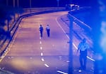 New Orleans police walk up the Almonaster Avenue bridge after a deadly shooting in New Orleans, Sunday, Nov. 17, 2024.