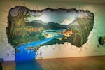 Mike Bennett commissioned a mural of a prehistoric Columbia River that breaks through the wall and rushes through a hallway inside Dinolandia. Mount Hood is visible in the background of the mural. 