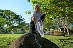 A woman sprinkles water on a stone marking a mass grave of victims of the 2004 Indian Ocean tsunami in Banda Aceh, Indonesia, Thursday, Dec. 26, 2024.