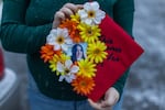 Amythist McCart shows her high school graduation cap adorned with a photo of her friend, missing teenager Kit Nelson-Mora.