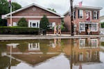 Pedestrians walk along Main Street in Highland Falls, N.Y. on Monday, July 10, after it was was damaged by flooding the previous day.