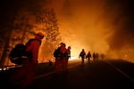 Inmate firefighters walk along Highway 120 during the Rim Fire near Yosemite National Park, Calif. in 2013. California currently has about 400 inmate firefighters battling the LA county wildfires.