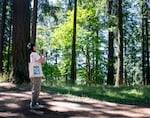 Birder Angela Baek watches for some new birds to add to her list in Mt. Tabor Park in Portland, Ore., July 19, 2025. Baek, visiting from Los Angeles, likes to tell people that birding is somewhat like “real life Pokemon,” in that they can collect a list of birds they have and have not yet found.
