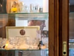 Bill Edge stores mementos in a glass-doored cabinet in his dining room, one of many pieces of donated furniture that have helped replace what he lost during the Santiam Canyon Fire in 2020. Edge is one of 17 named plaintiffs in a class action lawsuit that were recently awarded a financial settlement, holding Pacific Power accountable for choosing to keep power lines on during a major windstorm.