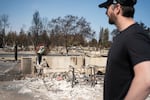 Melissa and Chris Matthews examine the remains of their family home in Spokane on August 14, 2026.