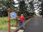 Florence, Ore., Mayor Joe Henry poses in front of the sign welcoming visitors to the Exploding Whale Memorial Park. The park is named in honor of the 1970 explosion of a rotting sperm whale on the Oregon Coast just outside of the city's limits.