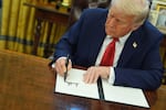 FILE - President Donald Trump signs an executive order in the Oval Office of the White House, Monday, Feb. 3, 2025, in Washington.