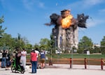 Crowds watch as the water tower on the Centennial Mills building is demolished on Aug. 17, 2026, in Portland, Ore.