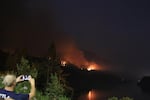 A person snaps a cell phone photo of the Eagle Creek Fire, visible from the nearby town Cascade Locks.