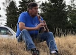 In this 2018 photo, Chief "Doc" Slyter plays one of his hand-carved flutes while watching lamprey tagging at Eel Creek.