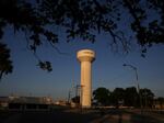 A water tower displays the town name "Uvalde" in big letters on its side.