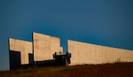 A visitor stands at an outdoor lookout point at the Flight 93 National Memorial in Shanksville, Pennsylvania, on September 11, 2025. Behind the person are two parallel walls that form a portal.