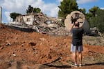 A man takes photos of a destroyed building that was hit in Iran's missile attack in Hod Hasharon, Israel, Wednesday.