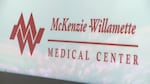 A white sign with red letters, reading, "McKenzie-Willamette Medical Center."