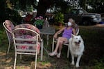 Fawnda Buck wears a KN95 mask as she looks up to the smoky sky as she rests in the yard, accompanied by one of her dogs, Porsche, in Sandy, Ore., on Aug. 5, 2026.
