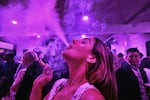 FILE - A guest takes a puff from a marijuana cigarette at the Sensi Magazine party celebrating the 420 holiday in the Bel Air section of Los Angeles, April 20, 2019. 