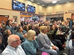 Residents in Newport gather at a meeting at city hall on Nov. 12, 2025. City Councilor CM Hall asked the crowd to use silent applause by raising and waving hands so it would not slow down the evening's proceedings.
