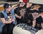Becky Lange, in an undated photo, is sitting next to shirts she hand-dyed for a Ground Score art show.