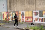 A person walks past a temporary art installment on one of the parcels of land purchased by 1803 Fund. 