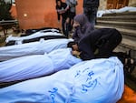 Relatives mourn over the bodies of people killed when the tent where they were sheltering was hit by Israeli bombardment, at the morgue of the Nasser medical center in Khan Younis in the southern Gaza Strip on Jan. 4.