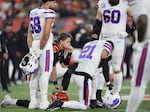 Quarterback Joe Burrow #9 of the Cincinnati Bengals and Jordan Poyer #21 of the Buffalo Bills take a knee after Damar Hamlin of the Bills collapsed following making a tackle during the first quarter at Paycor Stadium on January 02, 2023 in Cincinnati, Ohio.