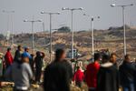 An Israeli army Merkava battle tank takes position as displaced Gazans cross the Netzarim corridor from the southern Gaza Strip into Gaza City on January 27, 2025. An unending stream of people marched up the coast of Gaza on January 27, carrying their belongings in plastic bags and repurposed flour sacks through the central city of Nuseirat after Israel reopened access to the territory's north.