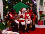 Ken Lee, far right, drove from Delaware with her family to take photos with Santa Luke at Mondawmin Mall.