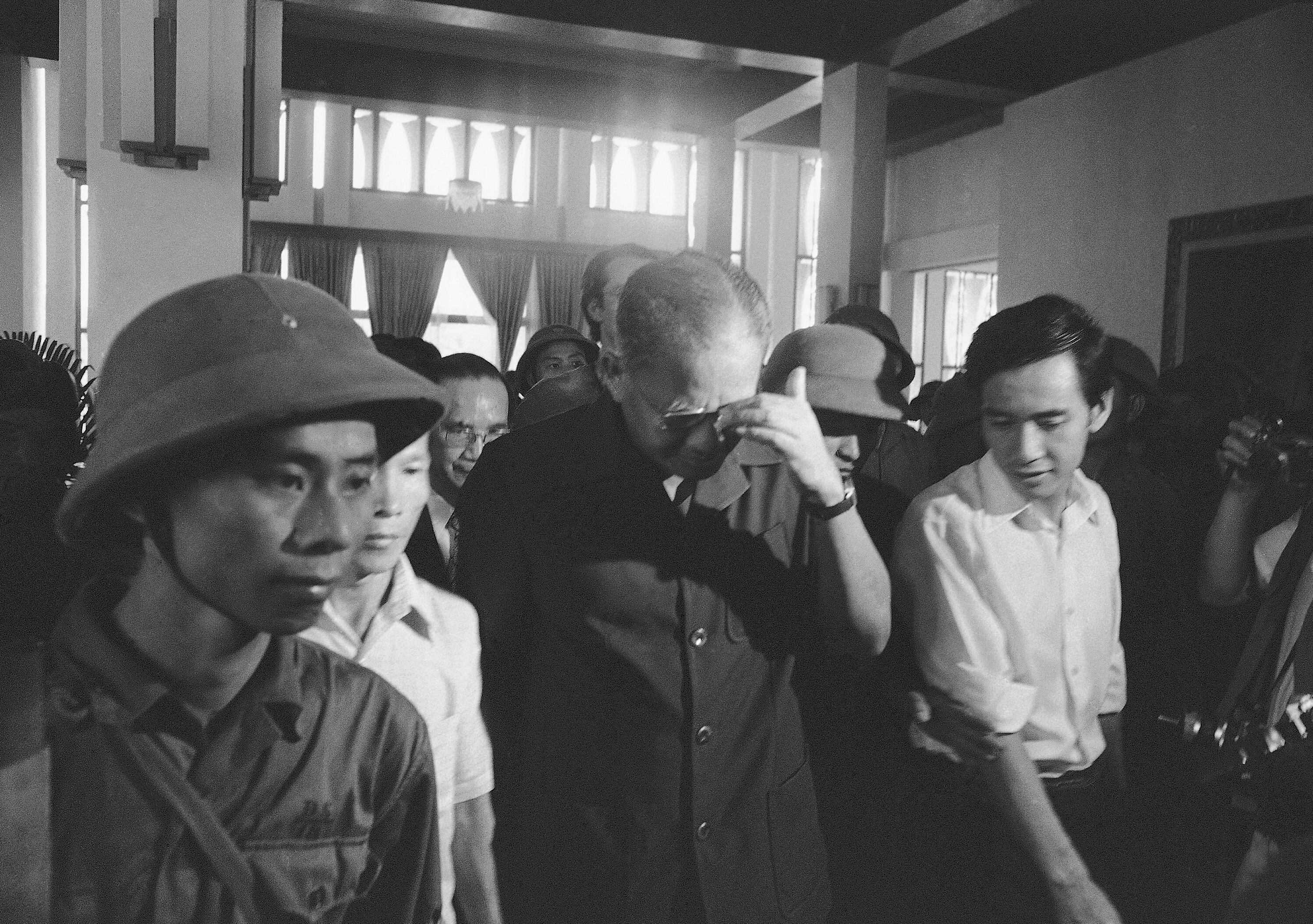 Defeated South Vietnam President Duong Van Minh (middle) walks out of Independence Palace after surrendering to PRG forces in Saigon on May 1, 1975.