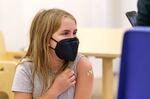 Elena Pitzel, 10, of Milwaukie, shows off her bandage after receiving her vaccination.