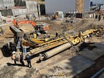 A large yellow crane lying on its side at a construction site.