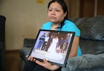 Rosalina Guzman holds a photo of her and her husband, Roman, from their wedding day.