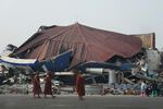 Buddhist monks walk past a collapsed building after a powerful earthquake in Naypyitaw, Myanmar, on Saturday.