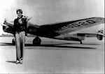 Amelia Earhart stands next to her Lockheed Electra 10E in 1937.