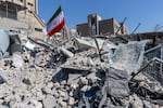 An Iranian flag is planted in the rubble of a police station, damaged in airstrikes on March 3, 2026 in Tehran, Iran.