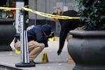 Members of the New York police crime scene unit photograph bullets lying on the sidewalk as they investigate the scene outside the Hilton Hotel in midtown Manhattan where Brian Thompson was fatally shot.