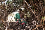 Ltesekwa sits in the shelter where he sleeps at this mountain campsite.