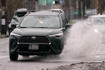 A car drives through a puddle on SE 11th Ave in Portland, Ore. on Thursday, Dec. 18, 2025.
